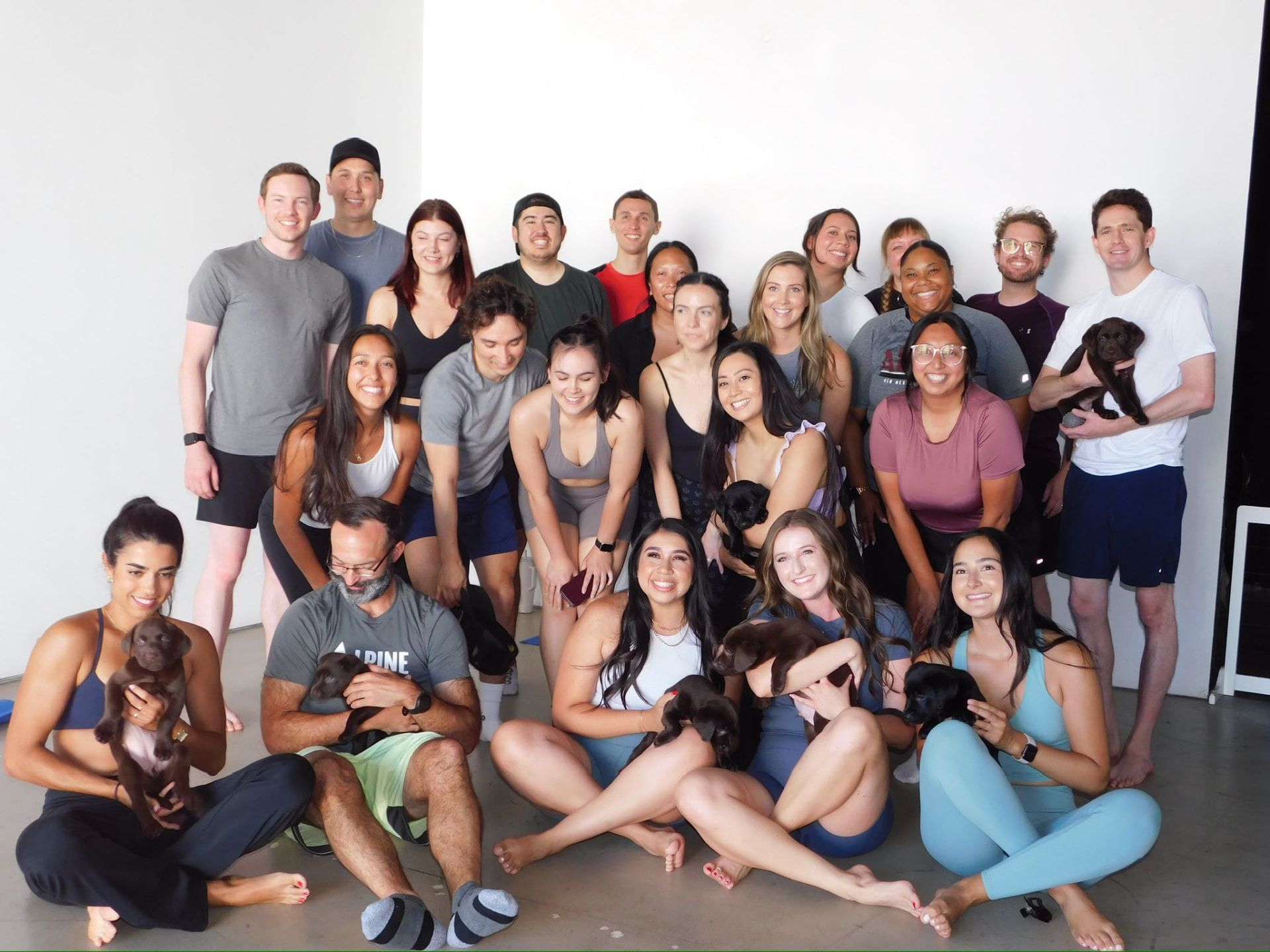 Large group photo at the end of a private puppy yoga party