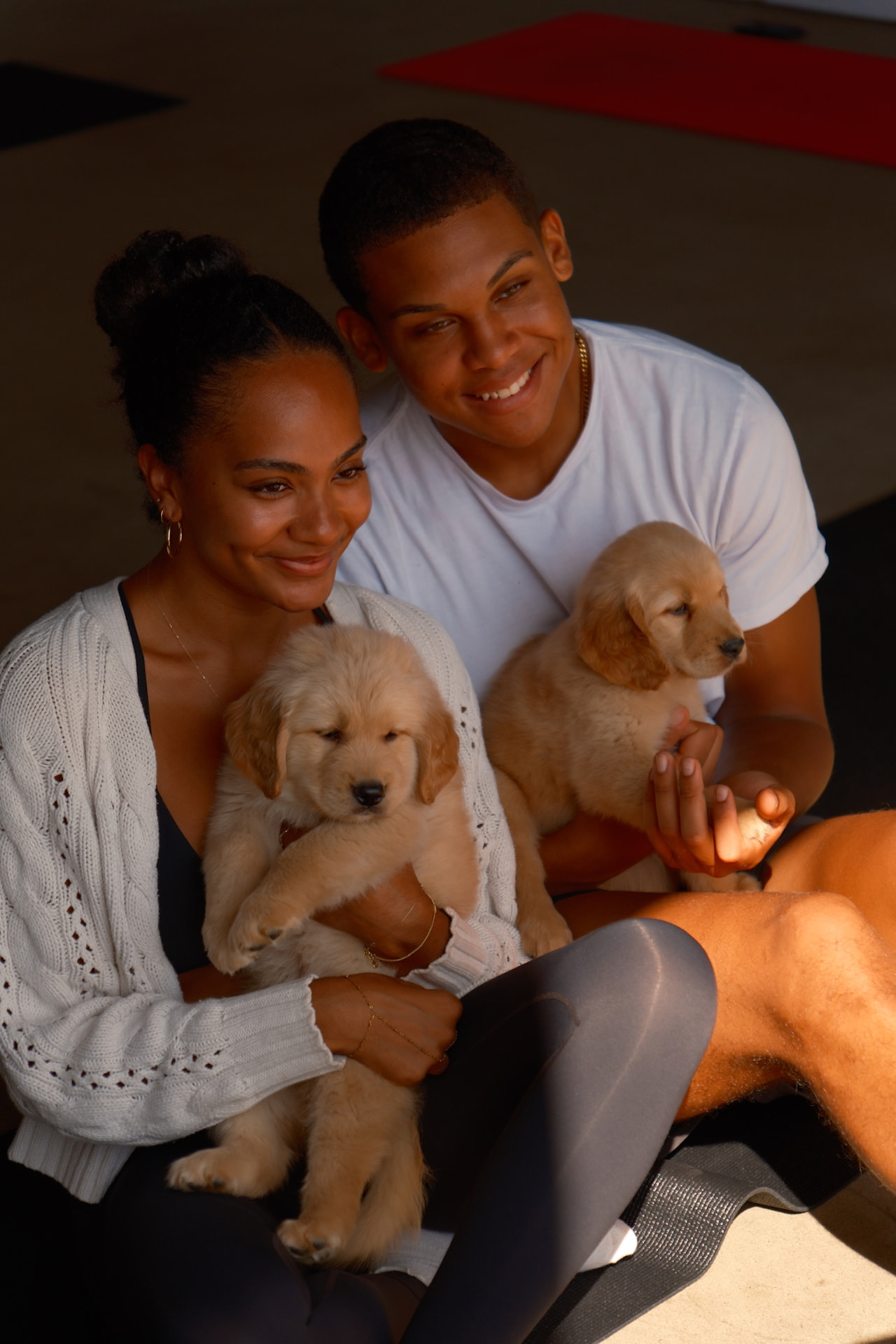 Couple cuddling golden retriever puppies at a puppy yoga event