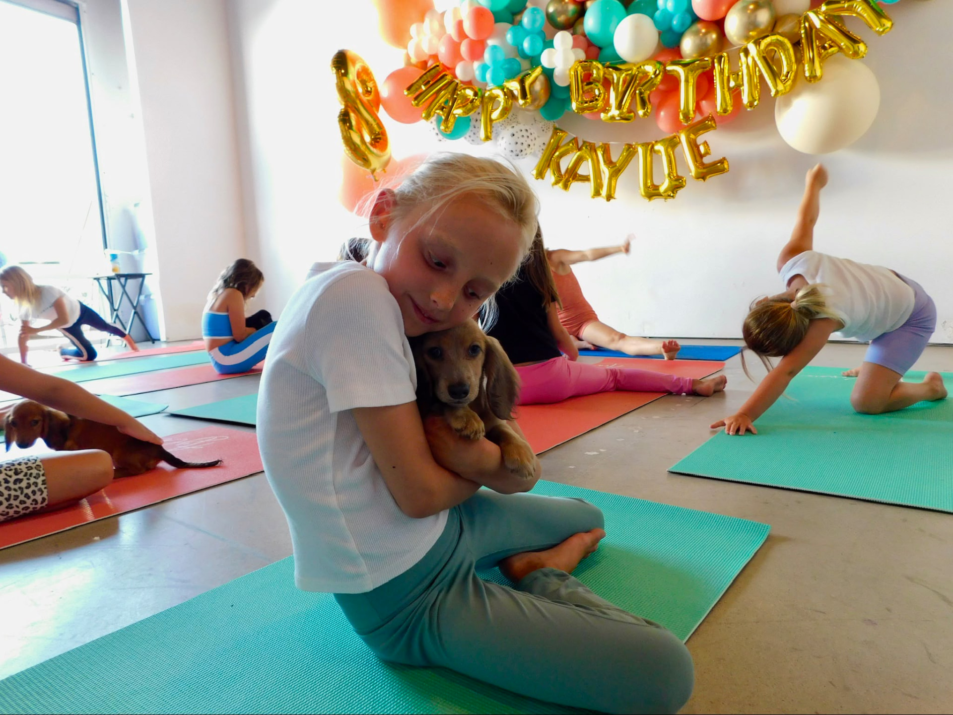 Birthday puppy yoga party with balloons and puppies